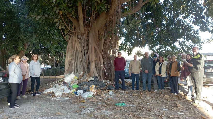 Un grupo de vecinos de la parcela del pasaje Ferrería de Heredia, el jueves de la semana pasada junto al problemático ficus, con basura, escombros y animales muertos al pie