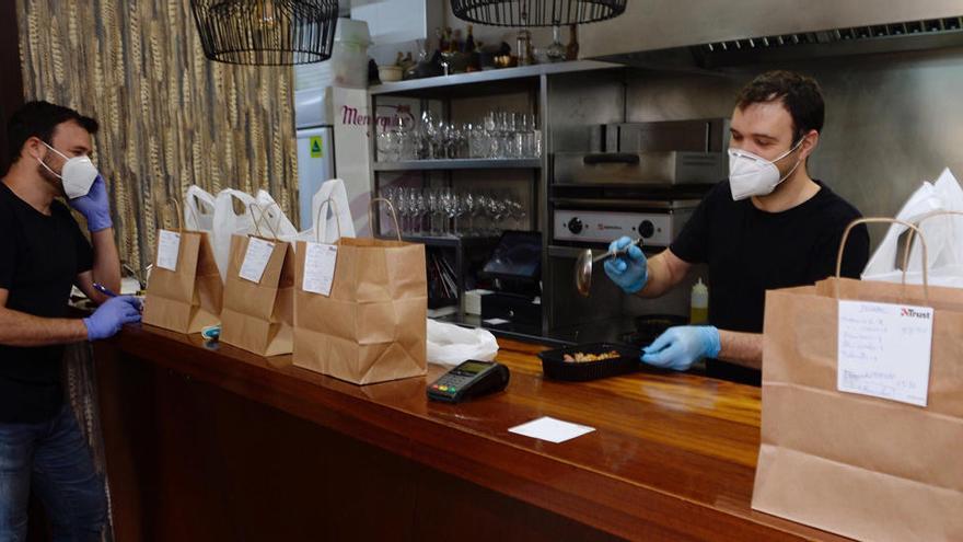 Dos trabajadores preparan algunos pedidos en un restaurante.