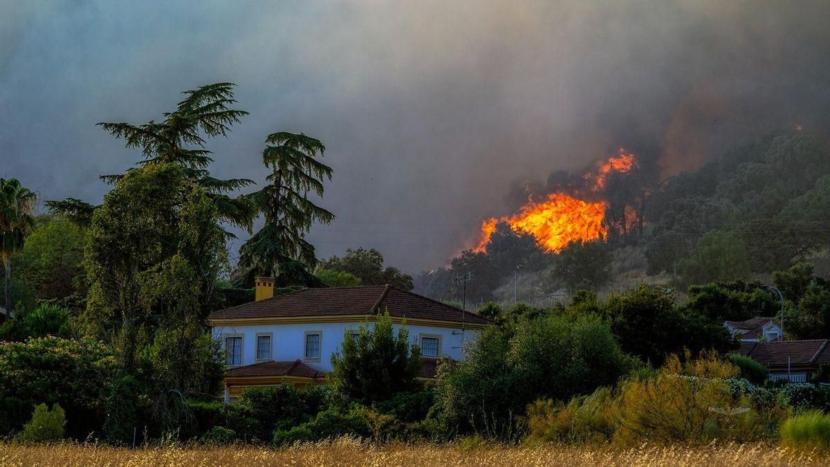 Una vivienda a las faldas de las Sierra, con el fuego por detrás.