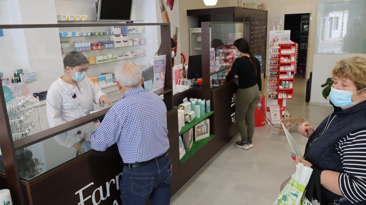 Usuarios con mascarilla en el interior de una farmacia de Castelló.