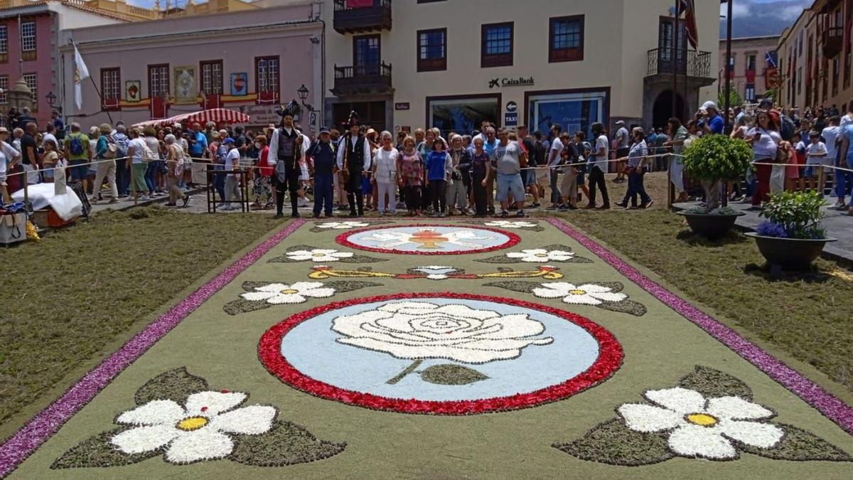 Alfombra de flores confeccionada en La Orotava con varios vecinos y vecinas posando.   | // D.P.