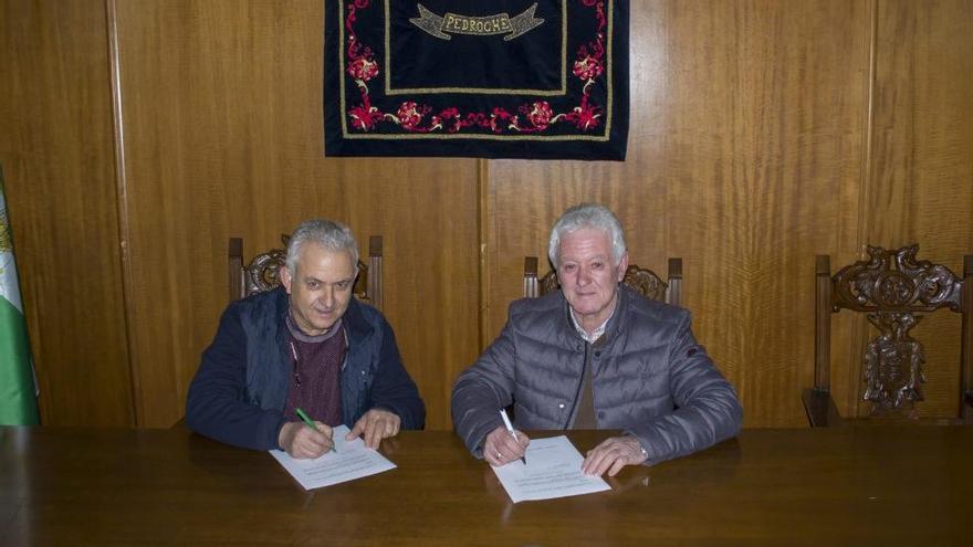 Uno de los herederos con el alcalde de Pedroche, Santiago Ruiz, firmando la adquisición.