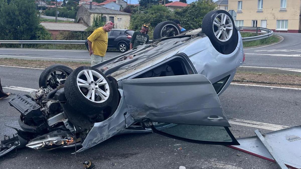 Un coche volcado tras un accidente en el cruce de Queirís, Coirós