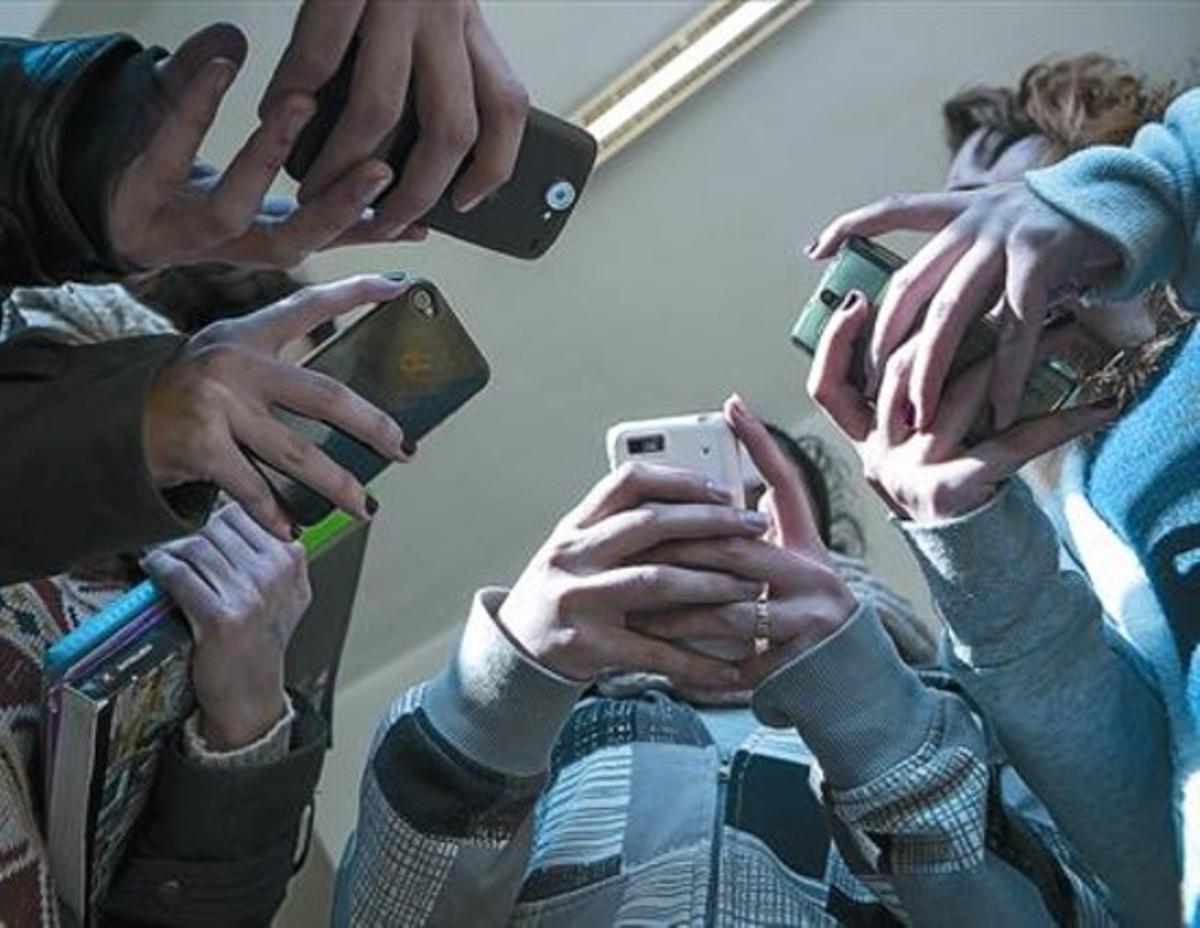 Menors consulten pàgines d’’informers’ a Facebook des del seu mòbil. Menors consulten pàgines d’’informers’ a Facebook des del seu mòbil.