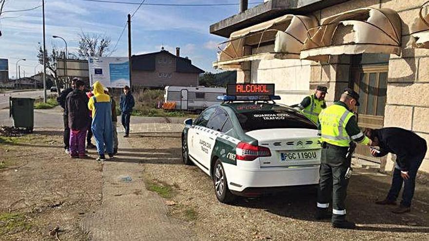 Dos agentes durante un control de alcohol a un joven durante el Entroido.