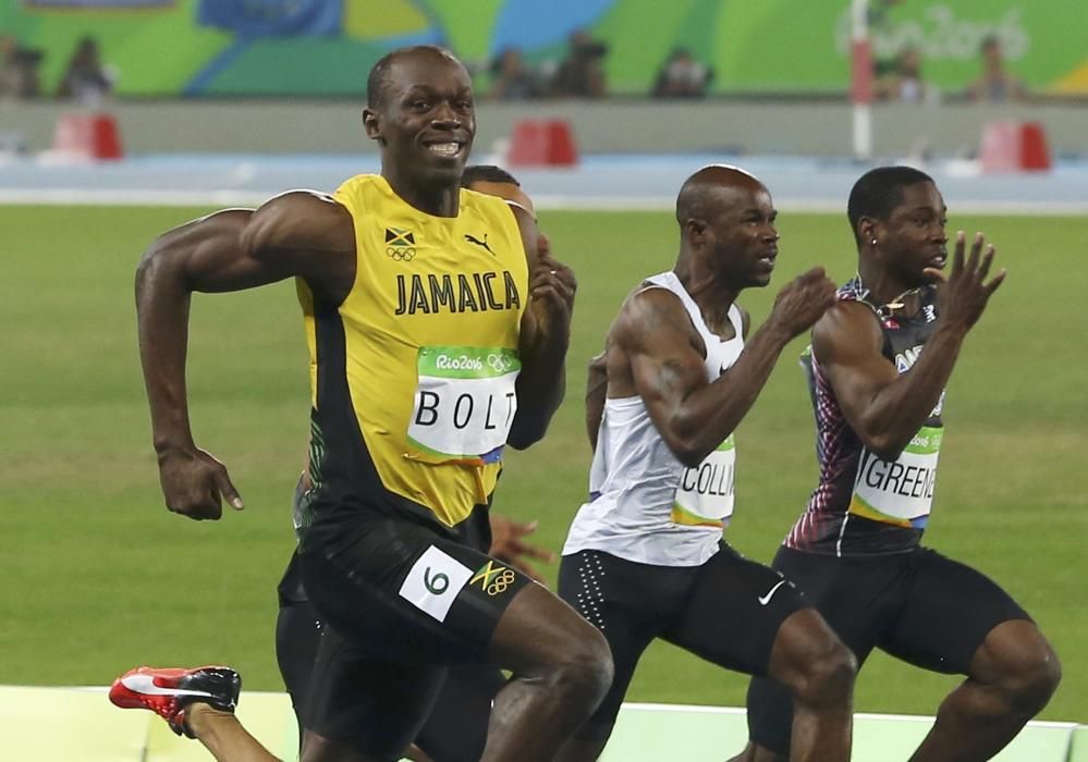 Usain Bolt mira a cámara mientras disputa las semifinales de los 100 metros lisos.