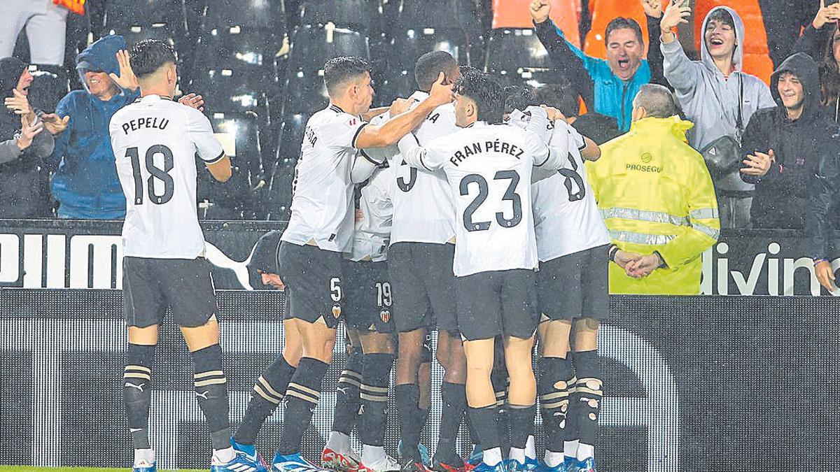 Los jugadores del Valencia celebran un gol frente al Cádiz bajo la lluvia