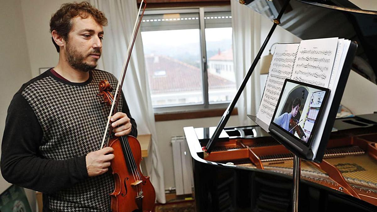 El profesor de música Manuel Cebrián ofrece una clase virtual a un alumno de violín desde su casa. |   // JOSE LORES 