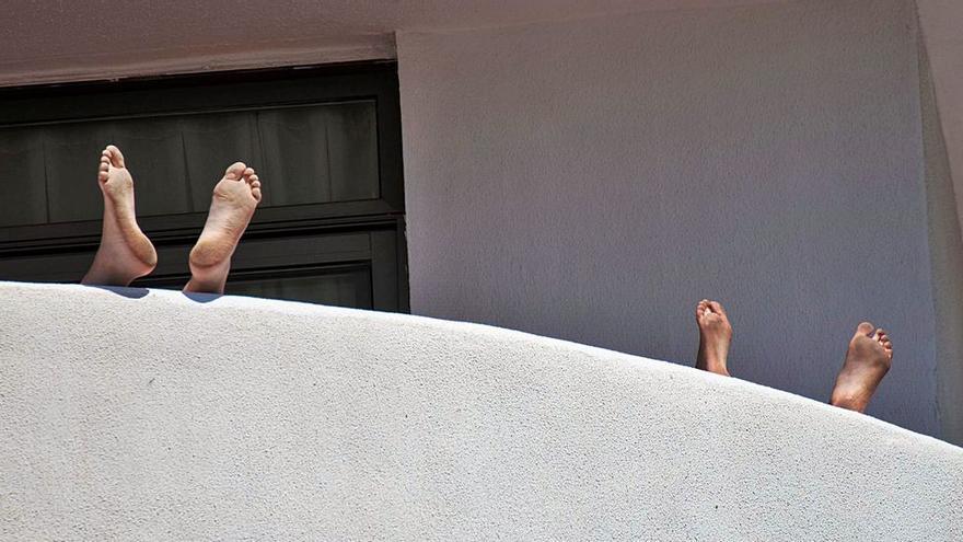 Dos estudiantes alojados en el hotel Palma Bellver del paseo Marítimo se relajan en la terraza de su habitación