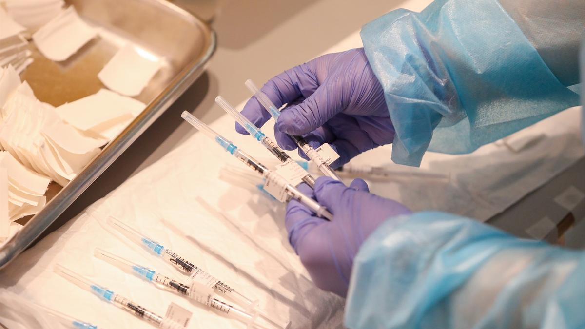 Un empleado sanitario sostiene una de las vacunas de Pfizer contra el covid-19.