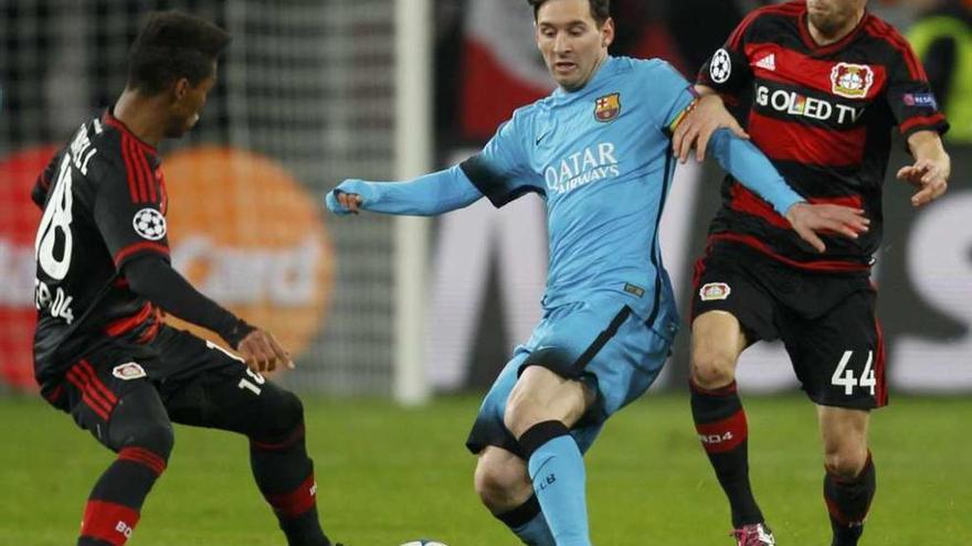 Messi es defendido por dos jugadores del Bayer Leverkusen, ayer en el BayArena.