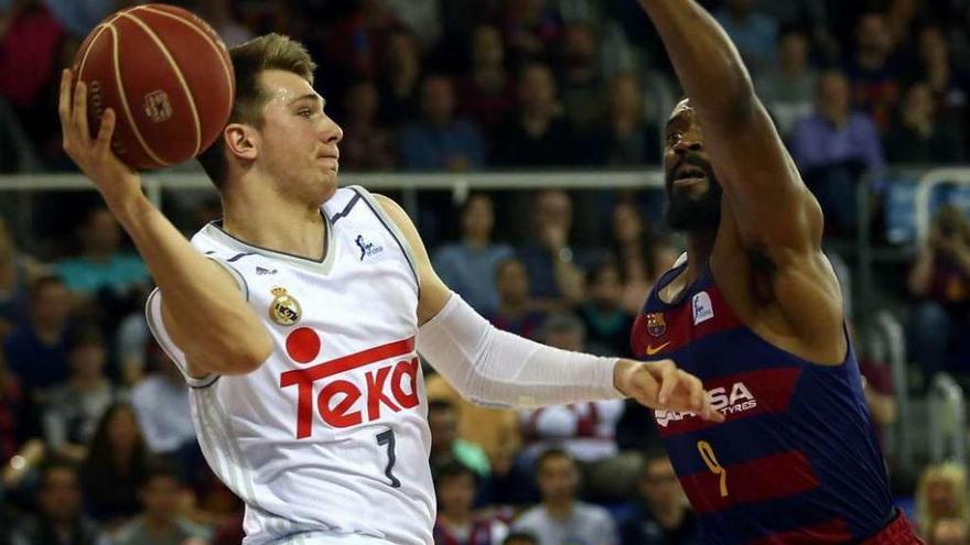 Doncic, del Real Madrid, encara el aro ante el azulgrana Lawal. // Toni Albir