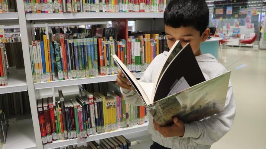 Un menor leyendo un libro en la biblioteca. |   // FERNANDO CASANOVA