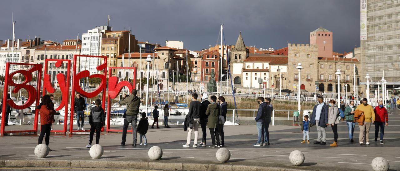 Turistas junto a Las Letronas de Gijón