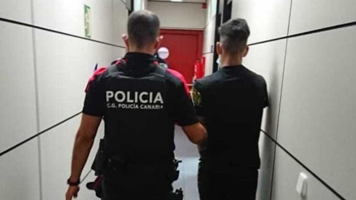 Agente de la Policía Canaria con uno de los presuntos agresores.