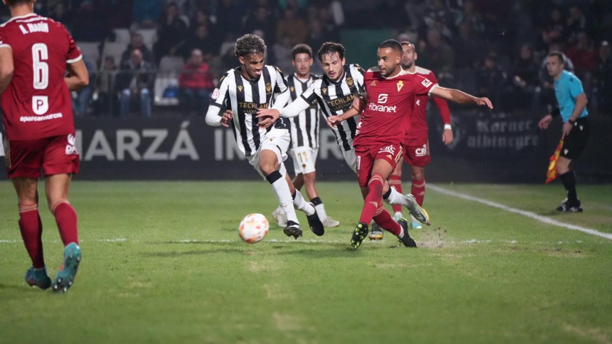 El futbolista visitante controla el juego.