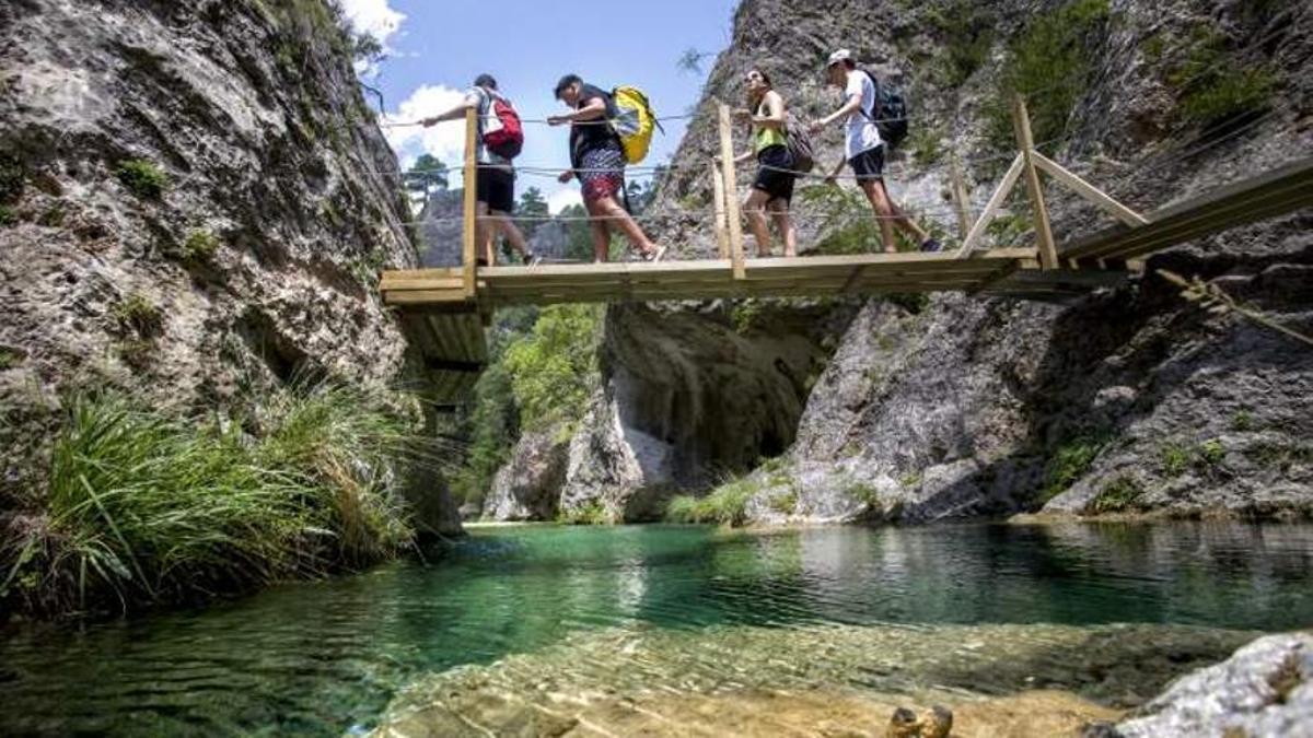 Varios turistas cruzan las pasarelas del Parrizal de Beceite.