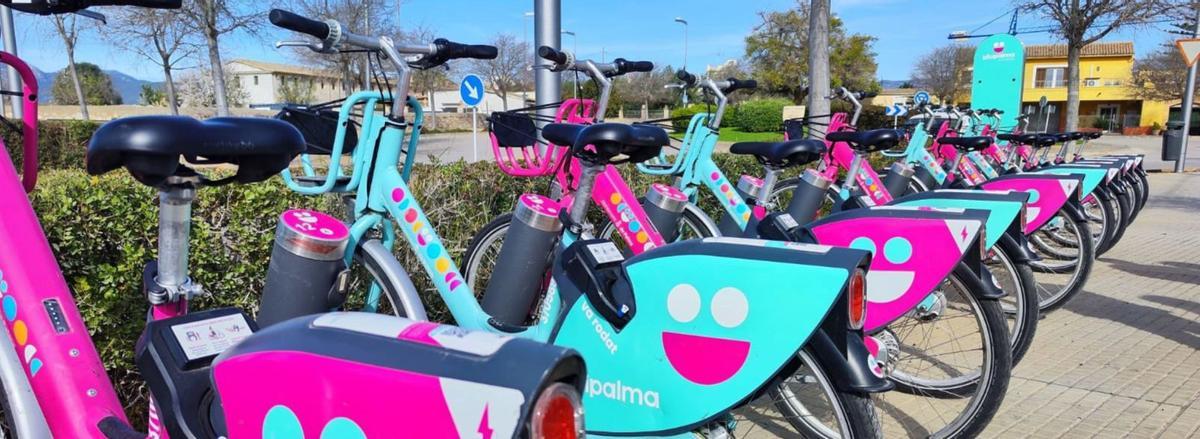 Pinke Elektroräder und konventionelle türkisfarbene Leihräder an einer Station von Bicipalma.