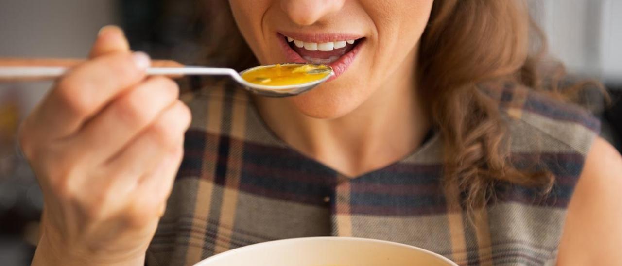 Imagen de archivo de una mujer tomando una sopa con la cuchara