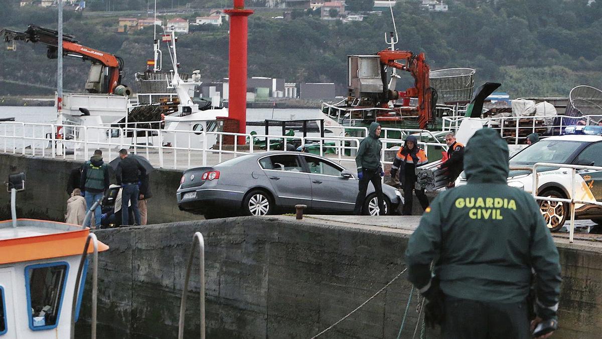 Agentes en el muelle de Domaio junto al coche que el conductor precipitó al mar y en el que murió Fadoua Akkar.