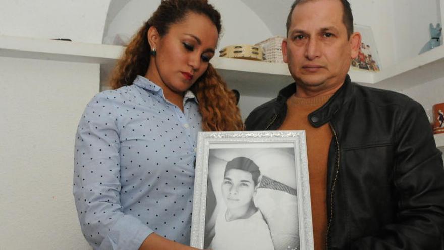 Los padres de la víctima muestran una foto de su difunto hijo Josué.