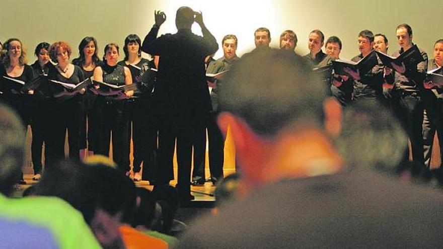 El coro de la Ópera de Oviedo, con su director, Patxi Aizpiri, a la cabeza, durante su actuación en el polideportivo de la prisión.