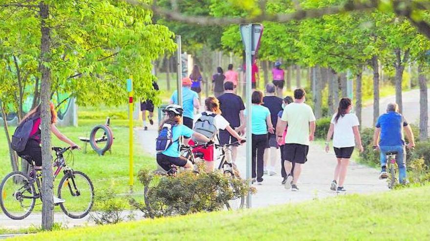 Gent anant en bicicleta i caminant, un exemple de la pràctica esportiva. | MARC MARTÍ