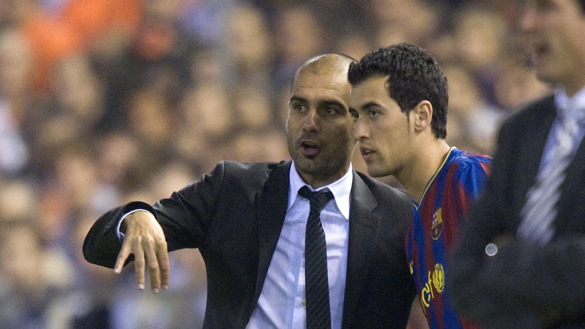 Sergio Busquets recibe los últimos consejos de Guardiola antes de sustituir a Xavi en un partido en Mestalla frente al Valencia en 2009