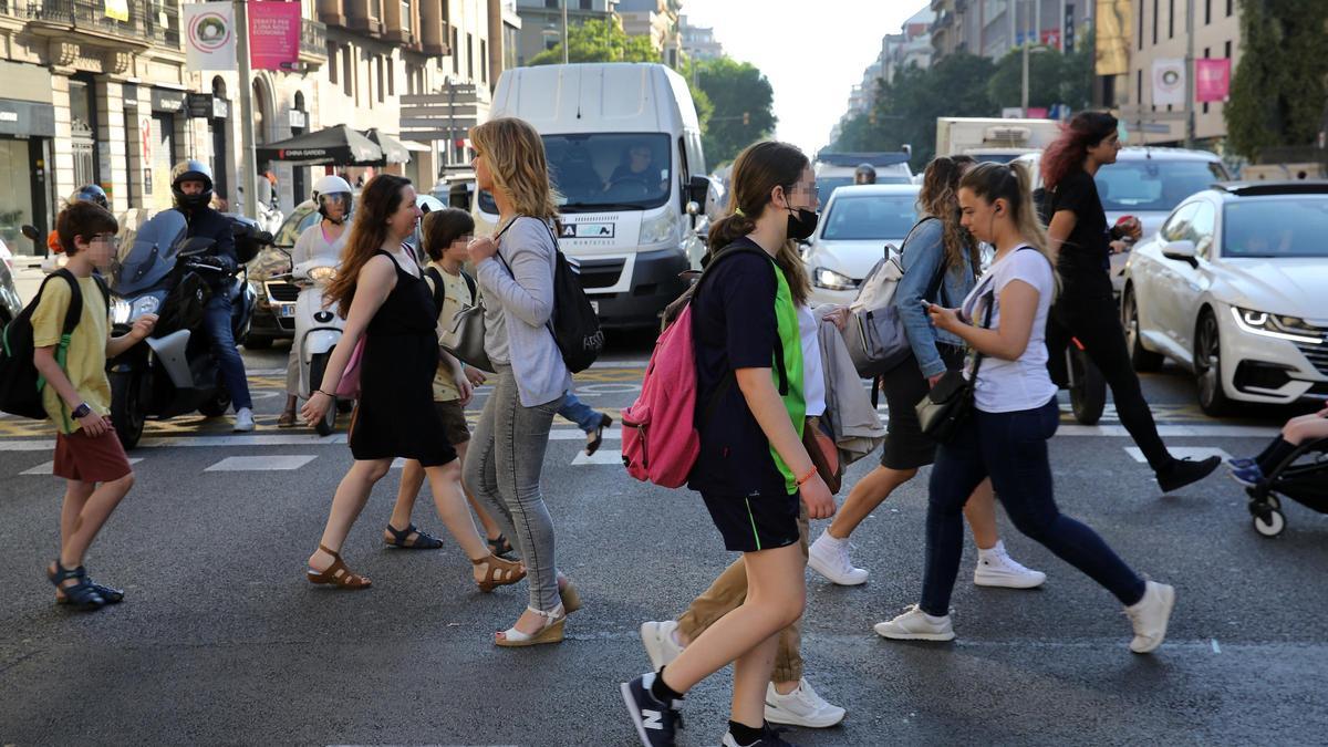Peatones cruzando la calle de Aragó ante la atenta mirada de los conductores, en junio de 2022