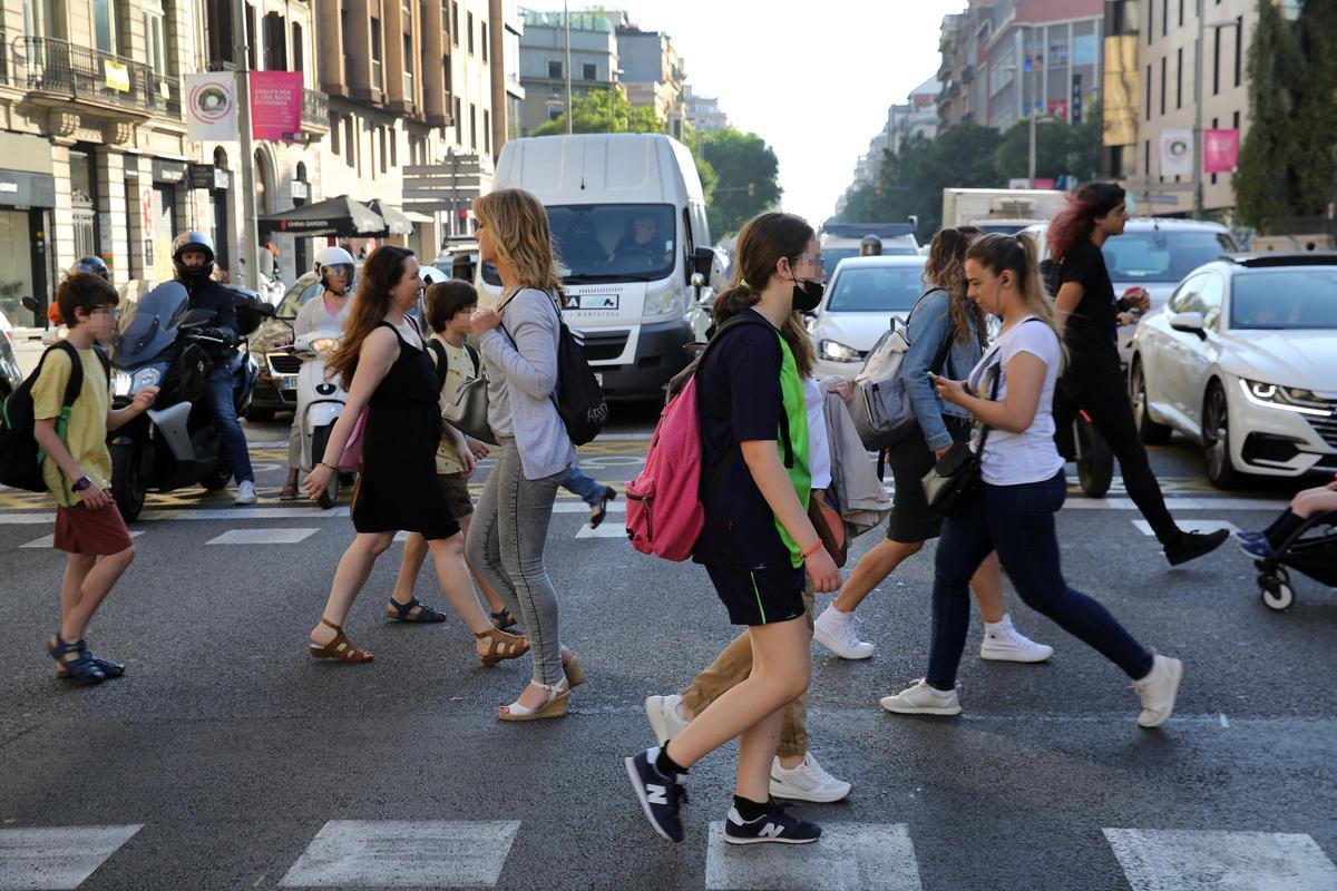 Peatones cruzando la calle de Aragó ante la atenta mirada de los conductores, en junio de 2022