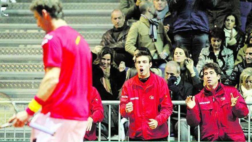 Marcel Granollers y Marc López, al fondo, animan a Juan Carlos Ferrero tras un punto del español.