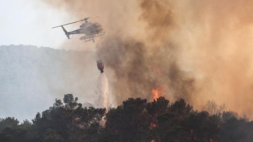 Un helicóptero descarga agua sobre una zona boscosa en llamas, el pasado 12 de abril en el incendio de es Cubells.