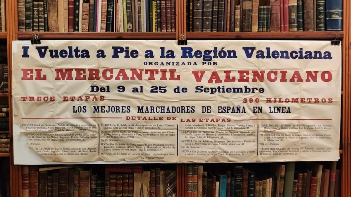 El cartel anunciador de la primera vuelta a pie organizada por El Mercantil Valenciano expuesto en la librería Rafael Solaz