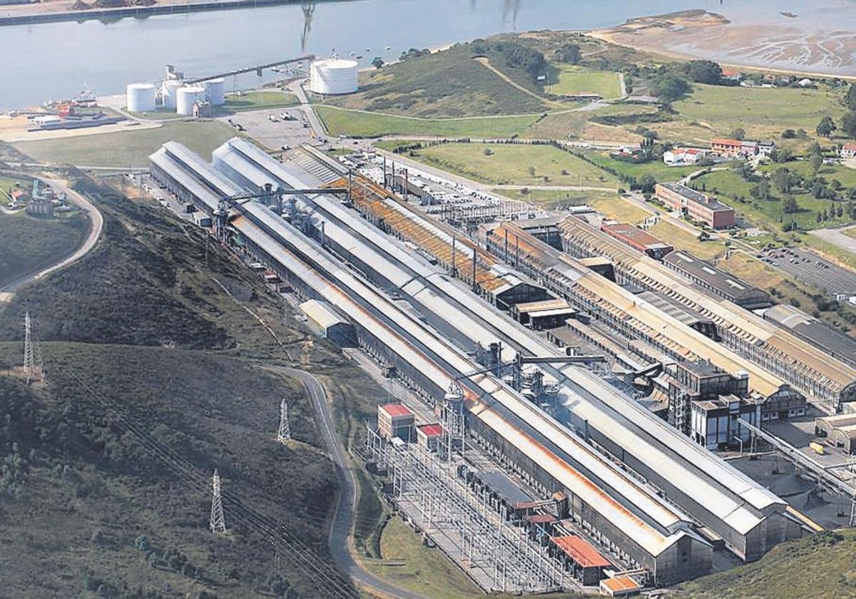 Instalaciones de Alu Ibérica, antigua Alcoa, con el muelle en el puerto de Avilés al fondo.