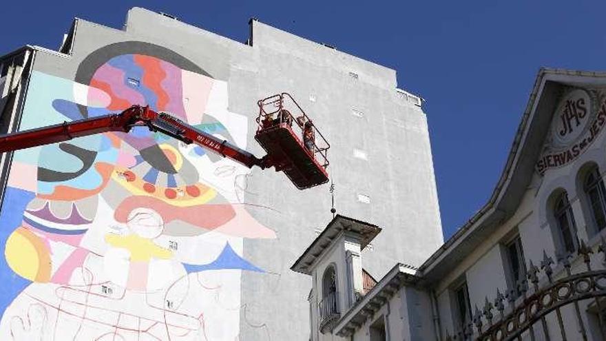 Trabajo de pintura en el mural de Urzáiz, 62, ayer. // R. Grobas