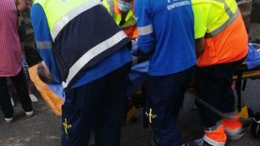 Los trabajadores de emergencias, llevando al herido hasta la ambulancia.