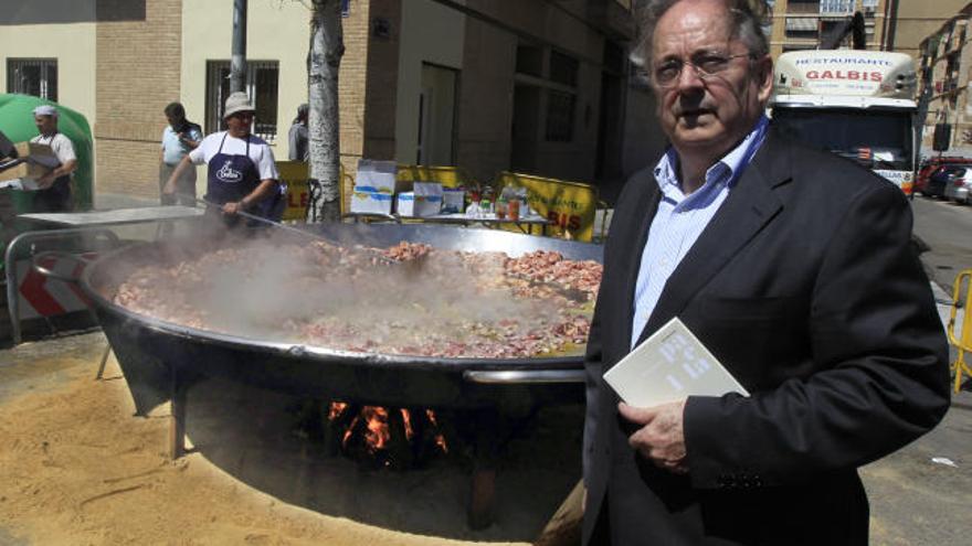 José María Pisa, con su libro, delante de una paella gigante