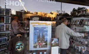 Cartells a les botigues de records als voltants del temple de la Sagrada Família anuncien la visita del Papa diumenge que ve.