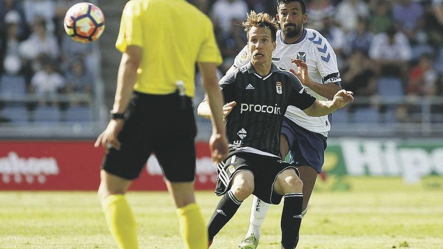 Susaeta protege el balón ante Carlos Ruiz en presencia del árbitro Pérez Pallas, ayer en Tenerife.