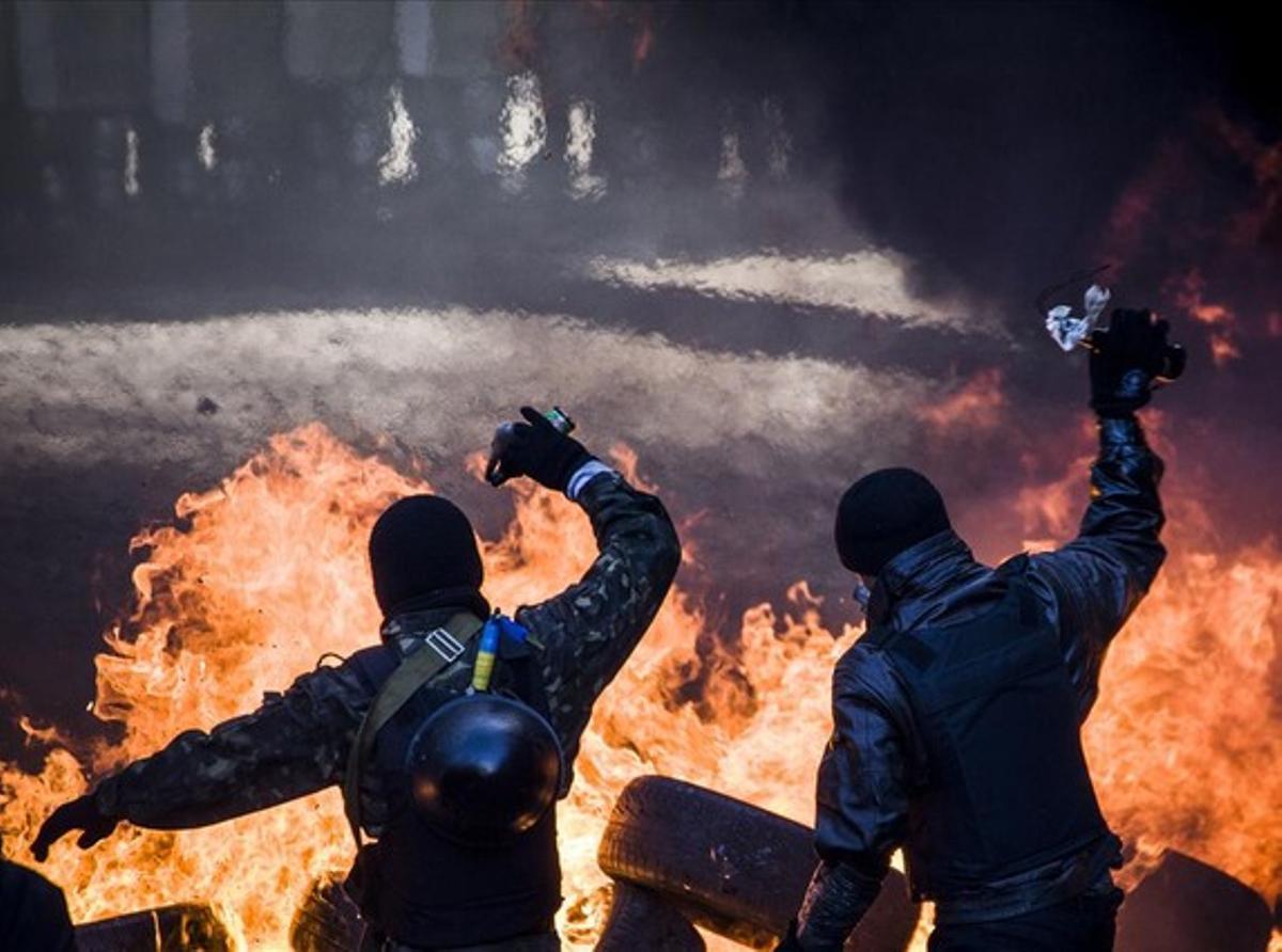 Dos manifestantes arrojan cócteles molotov durante las protestas.