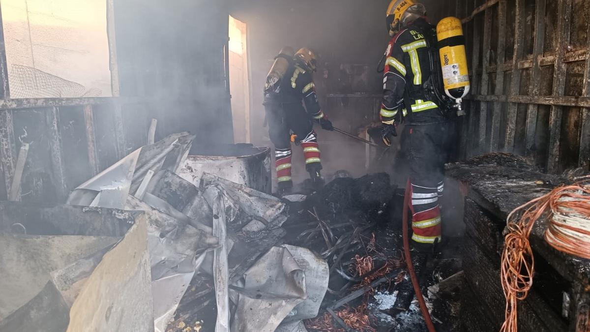 Bomberos del Consorcio de Emergencias apagan el incendio en el interior del contenedor.