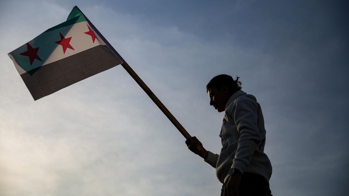 Un hombre con la nueva bandera de Siria en Damasco