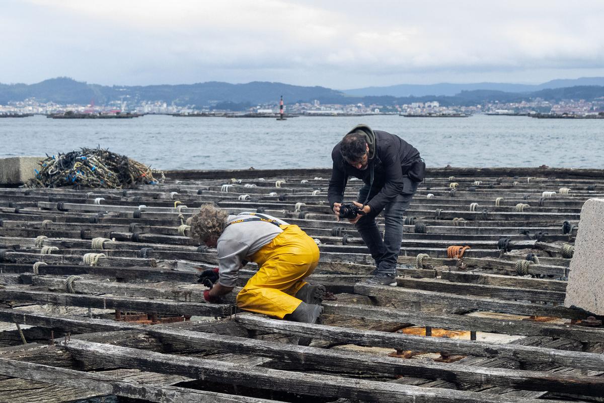Óscar Górriz fotografiando a un trabajador sobre una batea.