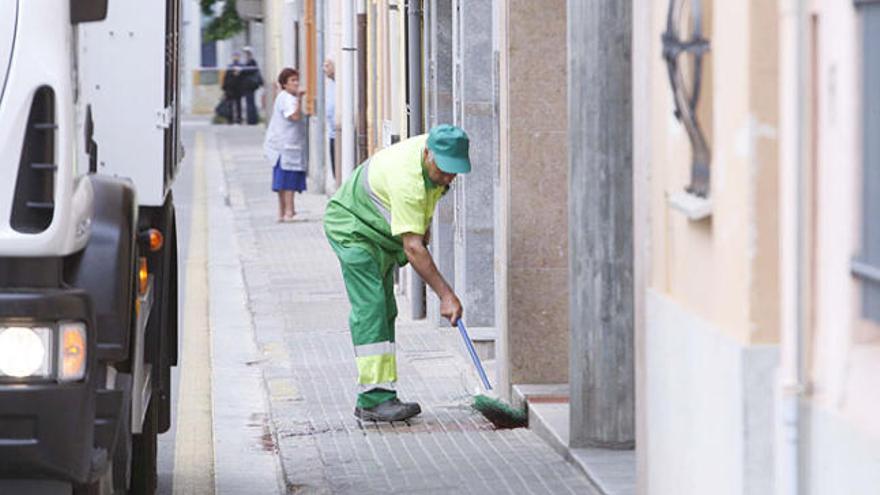 Un home neteja la vorera tacada del carrer Doctor Castany.