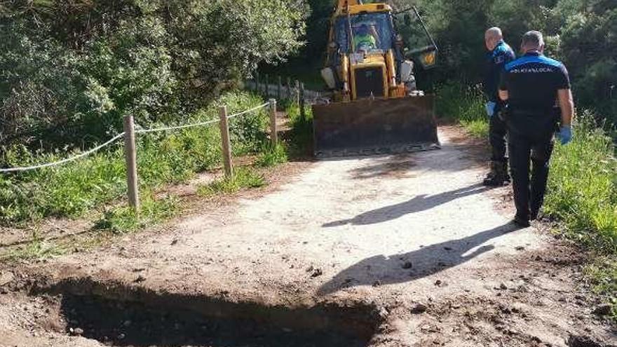 Una pala procede a tapar las zanjas cavadas por los percebeiros para evitar el paso de los mejilloneros.