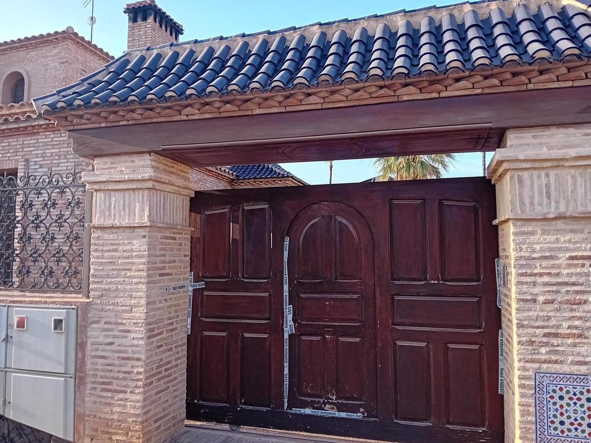 Una de las puertas de acceso a la vivienda precintada por la Guardia Civil