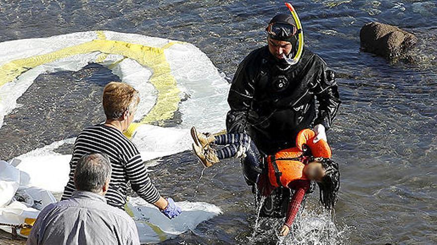 Un guardia griego rescata el cadáver de una niña en Lesbos.