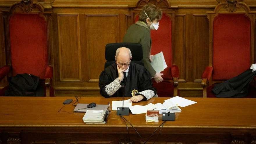 Una mujer con mascarilla pasa detrás del magistrado durante la lectura del veredicto. // Europa Press