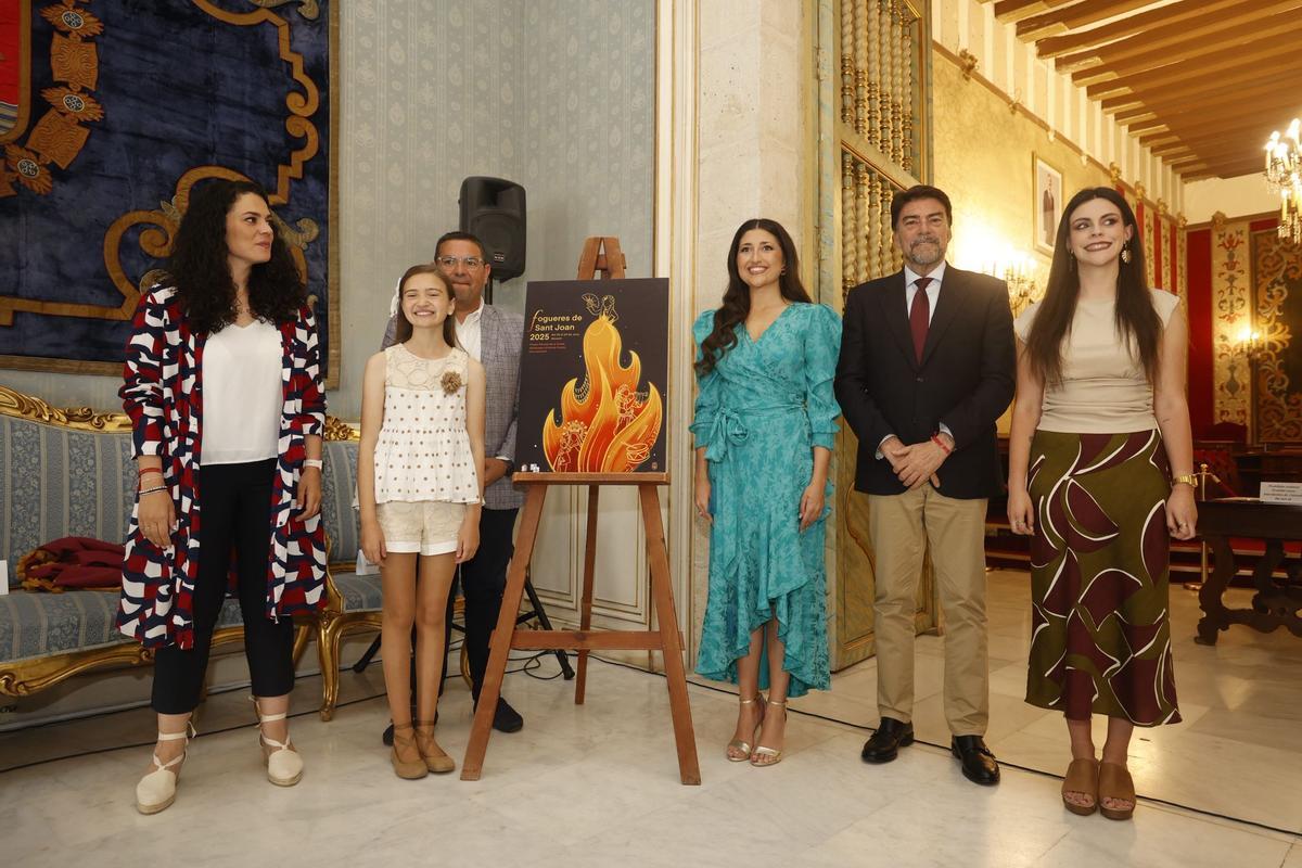 David Olivares, presidente de la Federació de Fogueres; Valentina Tárrega, Bellea del Foc infantil; Sofía Escolano, autora del cartel oficial; Adriana Vico, Bellea del Foc; Luis Barcala, alcalde de Alicante; y Cristina Cutanda, concejala de Fiestas; posan en la presentación oficial.