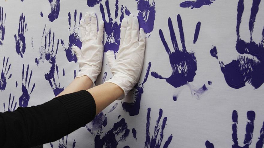 Una pared con manos pintadas en un acto feminista.